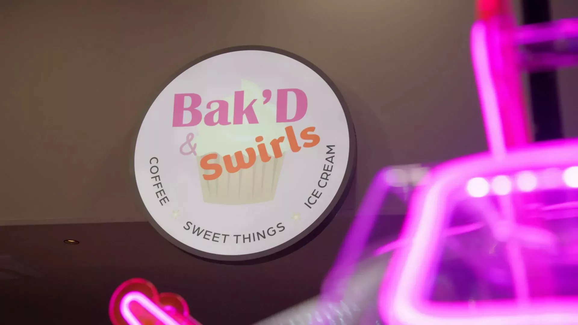 Bak'D & Swirls dessert shop sign offering coffee, sweet treats, and ice cream at Billing Aquadrome.