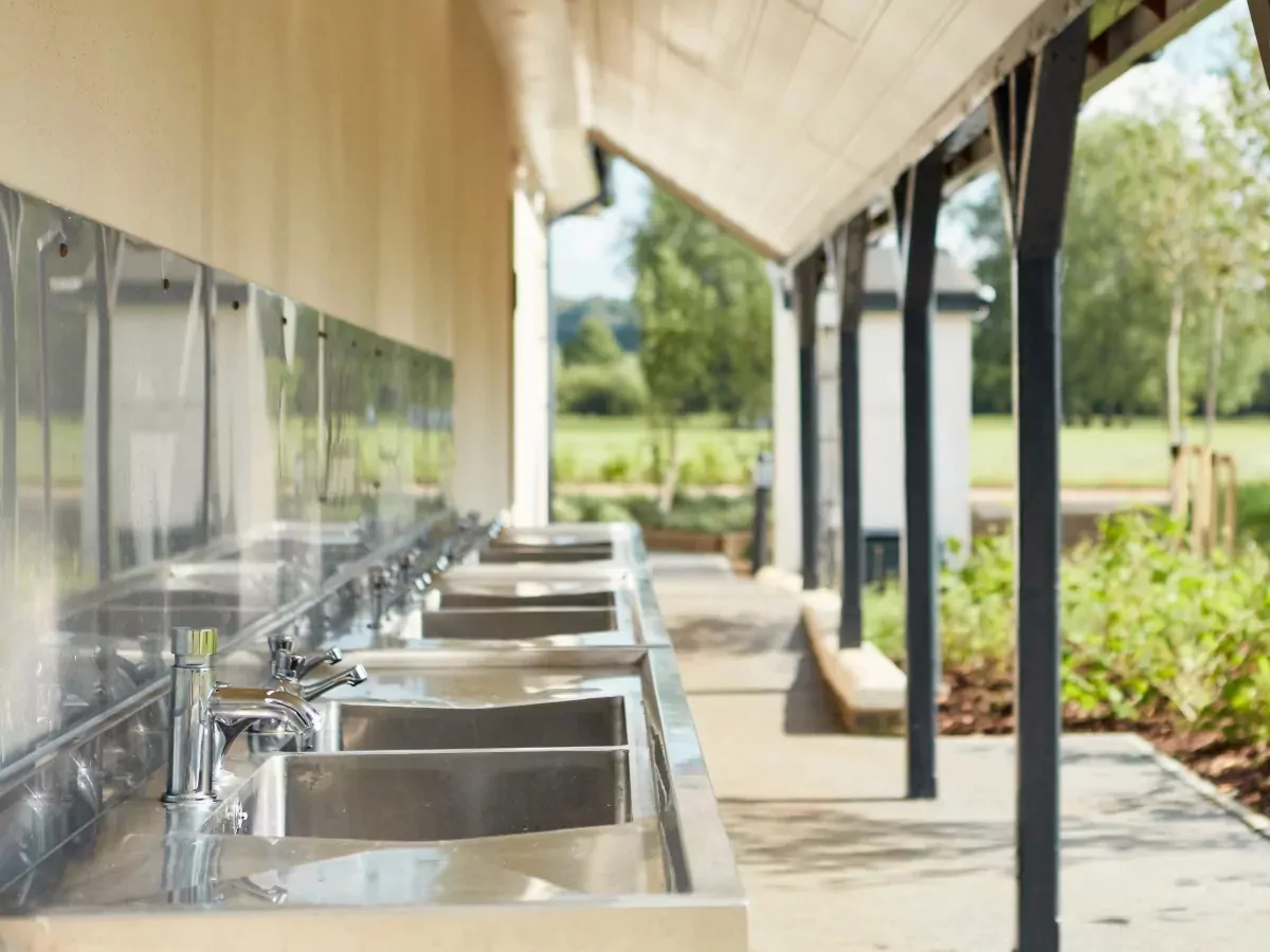 Row of outdoor stainless steel washing up sinks provided for camping and touring guests at Billing Aquadrome.