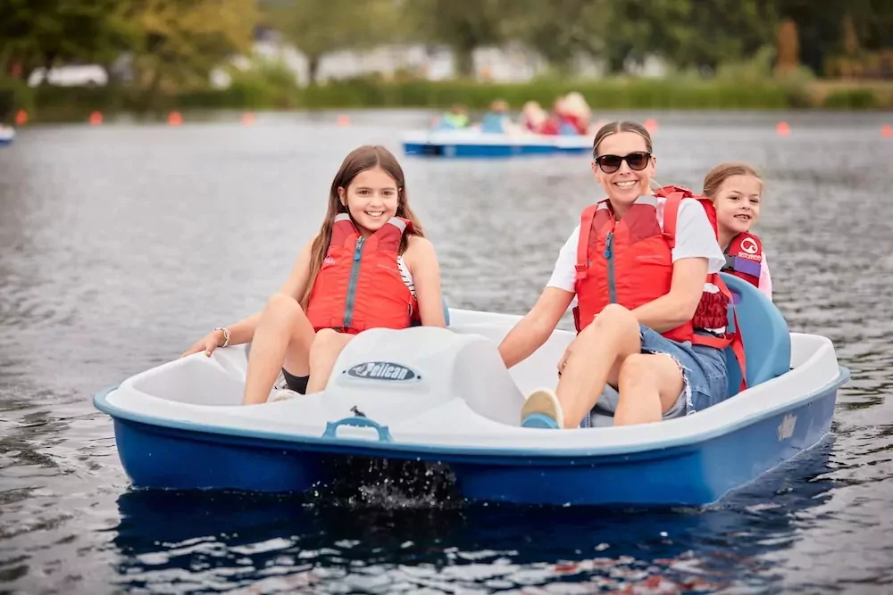 Family enjoying a ride on a blue pedal boat on the lake at Billing Aquadrome
