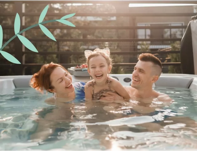 A smiling family enjoying a warm soak in a hot tub. A mother, father, and their young daughter, who is wearing cat-ear headbands, share a joyful moment together.