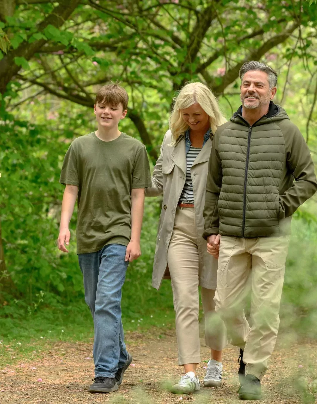 Family walking together along a scenic woodland trail at Billing Aquadrome.