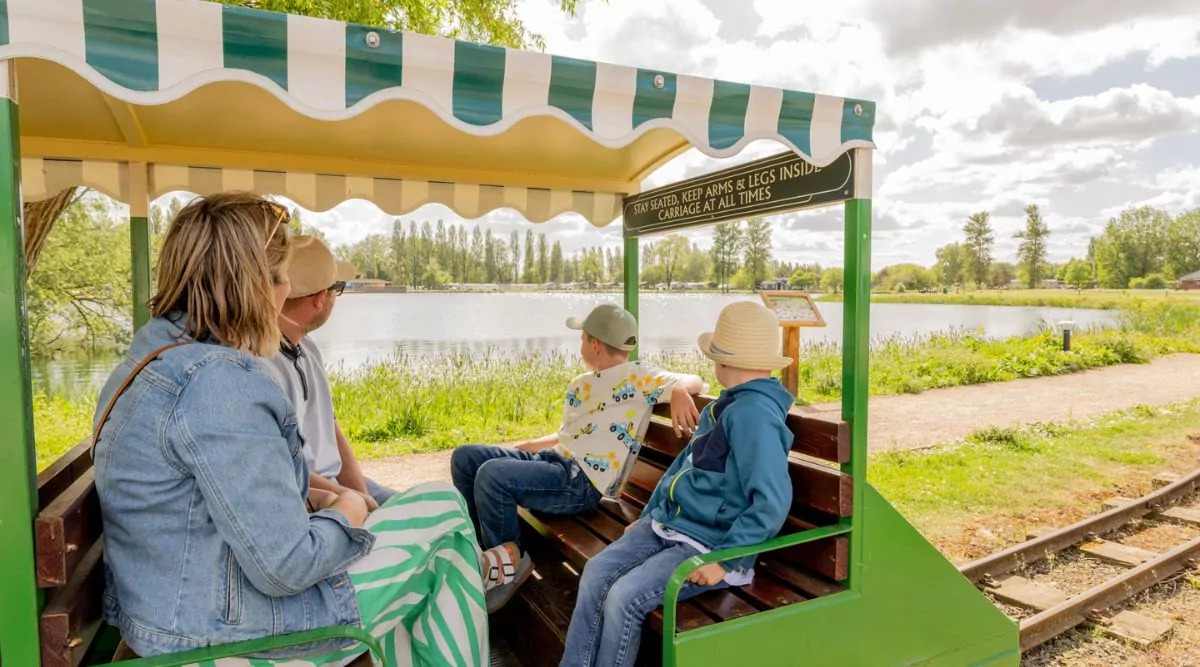 Family enjoying a scenic miniature train ride around the lake at Billing Aquadrome on a sunny day