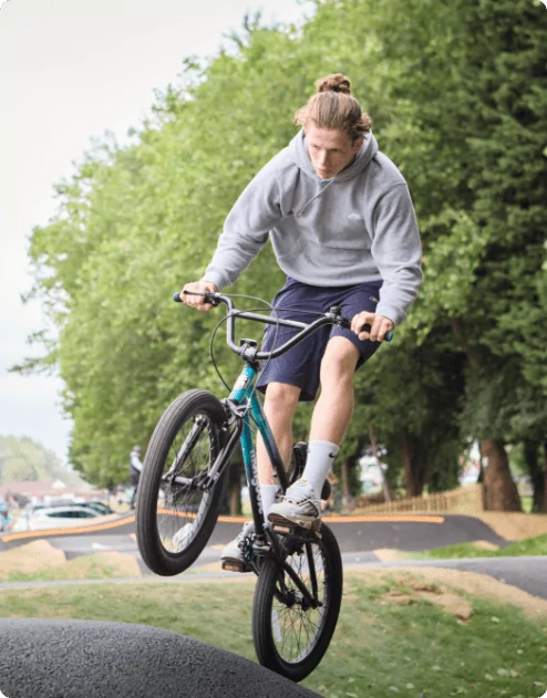A young man on his bike with the front wheel off the floor
