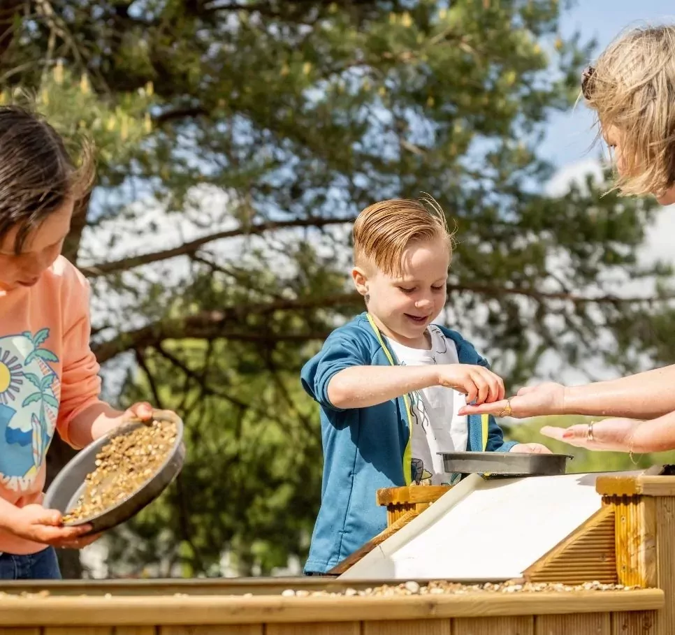 Children enjoying a gold panning activity at Meadow Bay Villages’ Billing Aquadrome, using sieves and water trays in a fun, outdoor experience