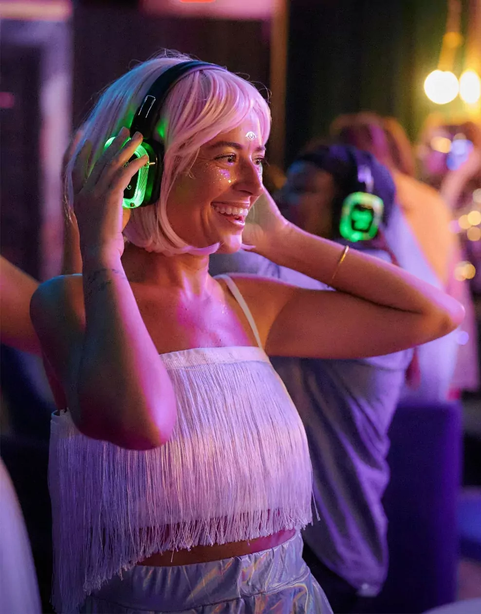 Woman enjoying a silent disco wearing glowing headphones and a fringed top at Billing Aquadrome