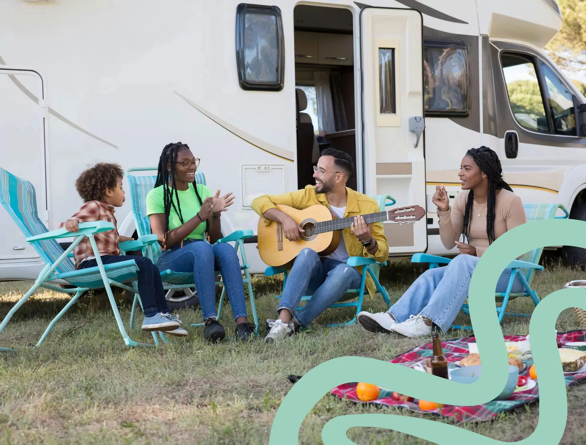 Friends and family relaxing outside a caravan with a picnic and live guitar music at Billing Aquadrome, part of Meadow Bay Villages.