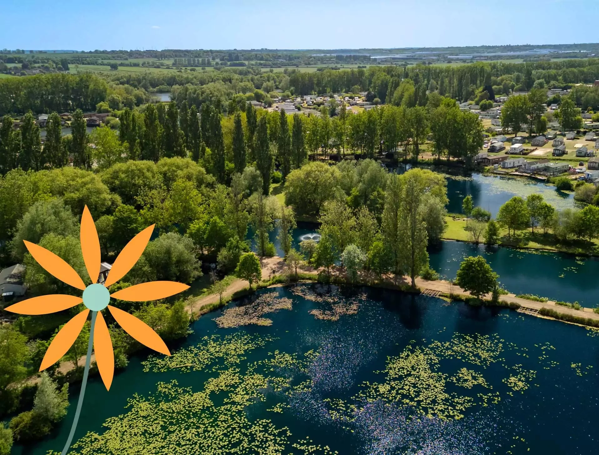 Scenic aerial view of Billing Aquadrome with lakes, woodland, and holiday lodges, part of Meadow Bay Villages.