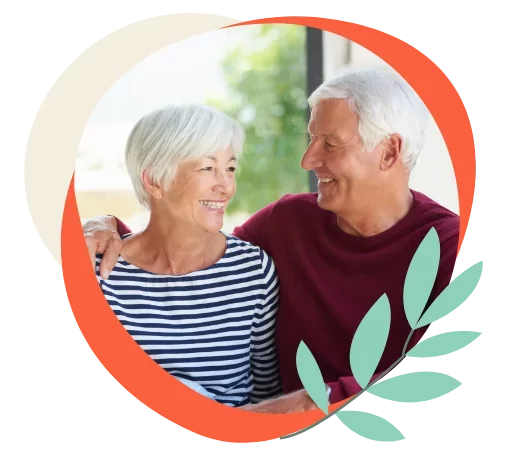 Older couple smiling and embracing, representing the warm and welcoming retirement lifestyle at Meadow Bay Villages.