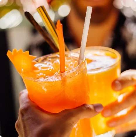 Bright and fruity cocktails being clinked together in a celebratory toast – capturing the relaxed and social atmosphere of evenings at Meadow Bay Villages.