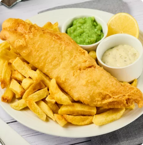 Traditional British fish and chips served with mushy peas, tartar sauce, and a wedge of lemon – a popular meal option at Meadow Bay Villages on-site dining venues.