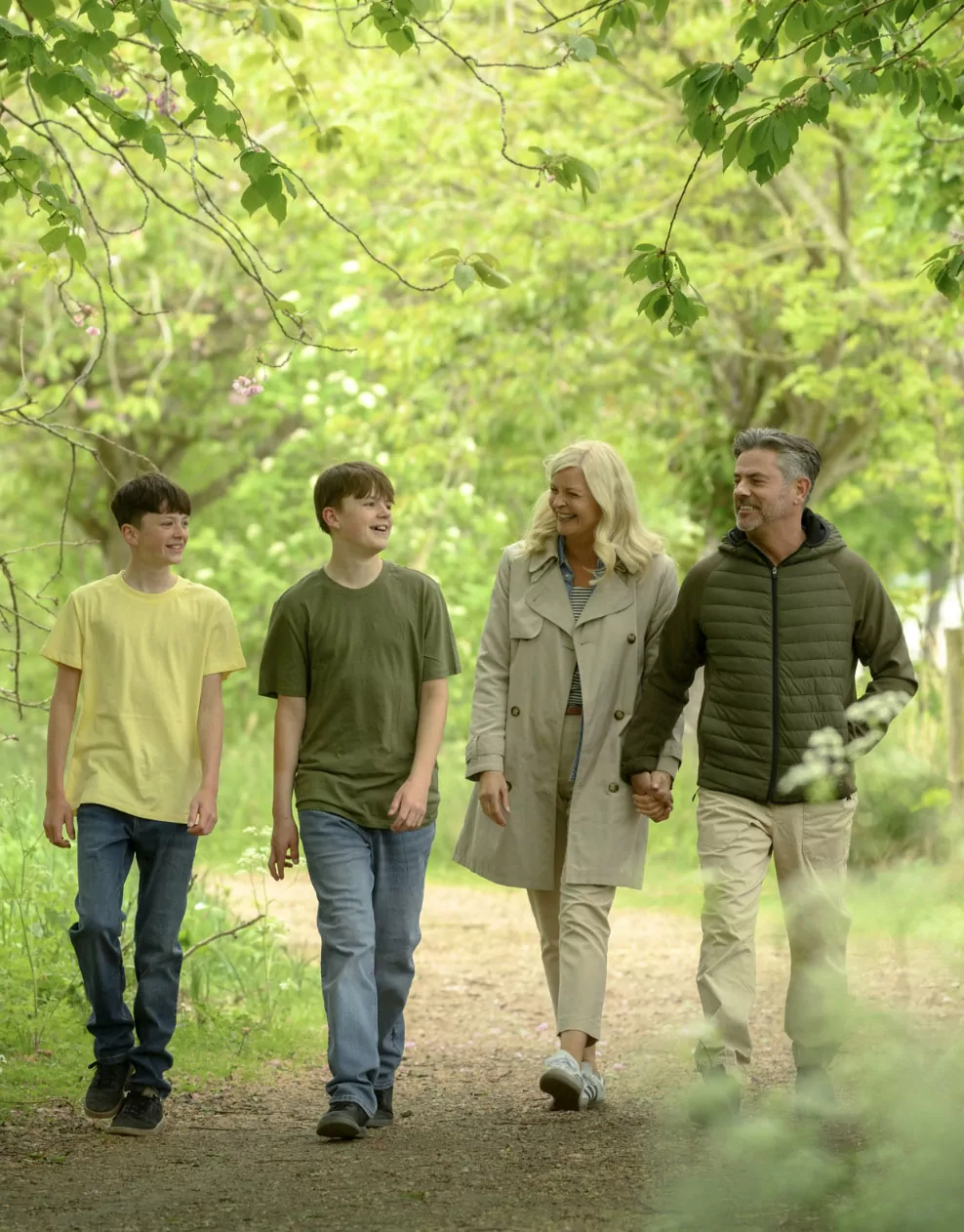 A family walking together along a scenic woodland trail surrounded by greenery at Billing Aquadrome.