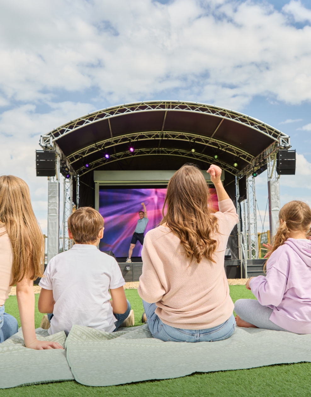 Families enjoying an outdoor amphitheatre show on stage at Billing Aquadrome.