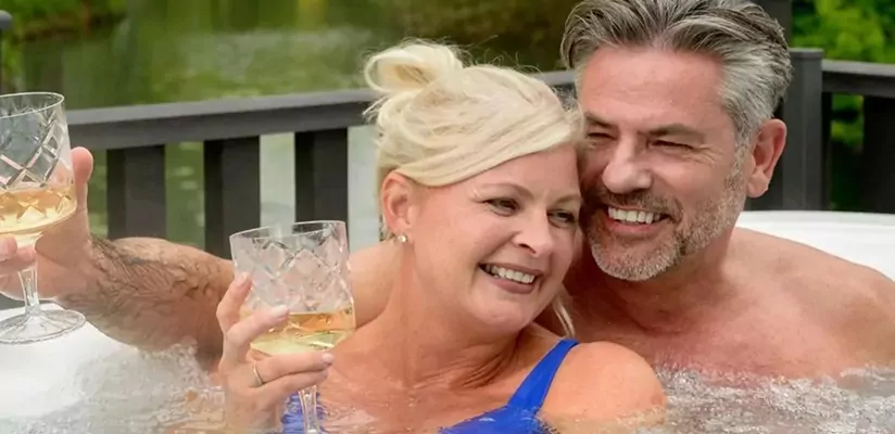 Couple relaxing together in a hot tub with drinks at Billing Aquadrome