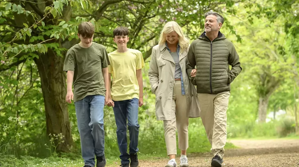 Family enjoying a peaceful walk along a woodland path surrounded by nature at Billing Aquadrome