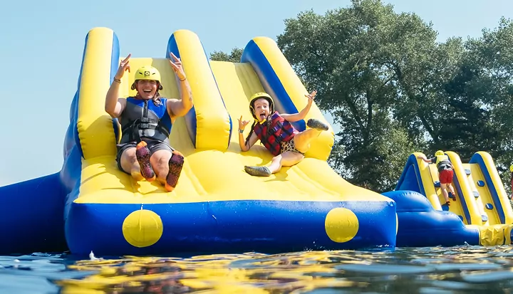 Family having fun on the inflatable aqua park obstacle course at Billing Aquadrome