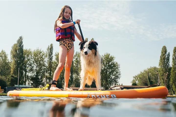 Child paddleboarding with a dog on the lake at Billing Aquadrome
