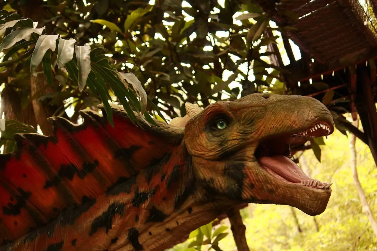 Animatronic dinosaur attraction surrounded by tropical plants at Billing Aquadrome.
