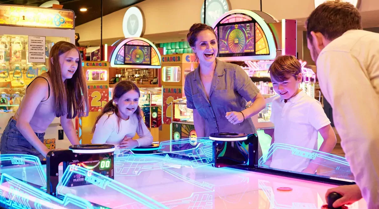 Family playing air hockey together in the arcade at Billing Aquadrome.