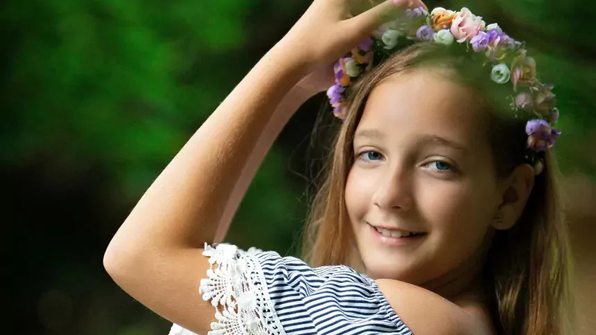 Smiling young girl wearing a handmade flower crown outdoors at Billing Aquadrome