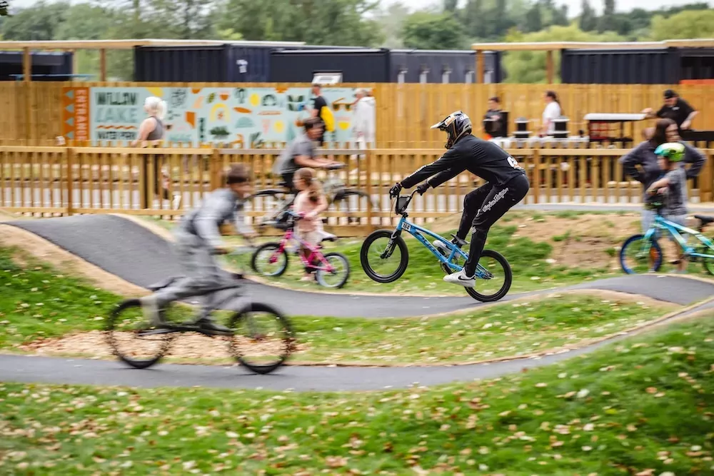 Cyclists of all ages riding and jumping on the BMX pump track at Billing Aquadrome