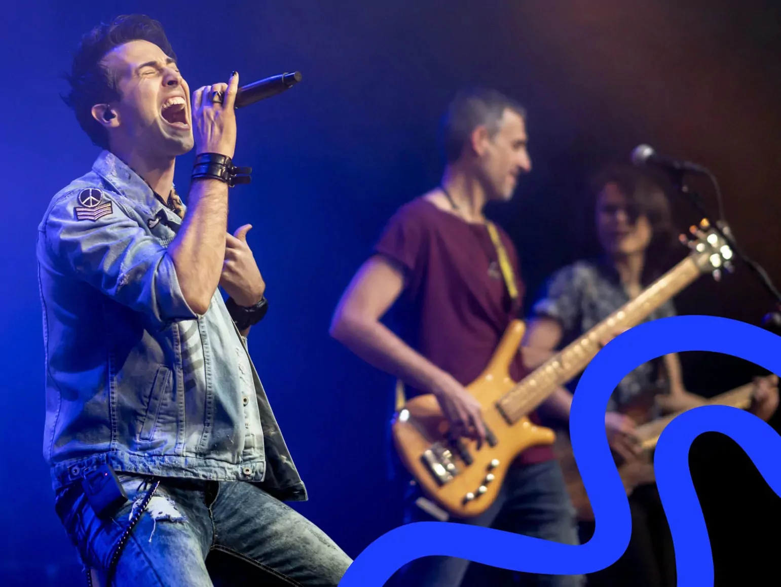 Energetic lead singer performing on stage with live band during an evening music event at Billing Aquadrome holiday park