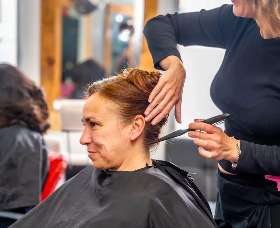Smiling woman getting her hair styled at the on-site hairdressing salon in Billing Aquadrome holiday park