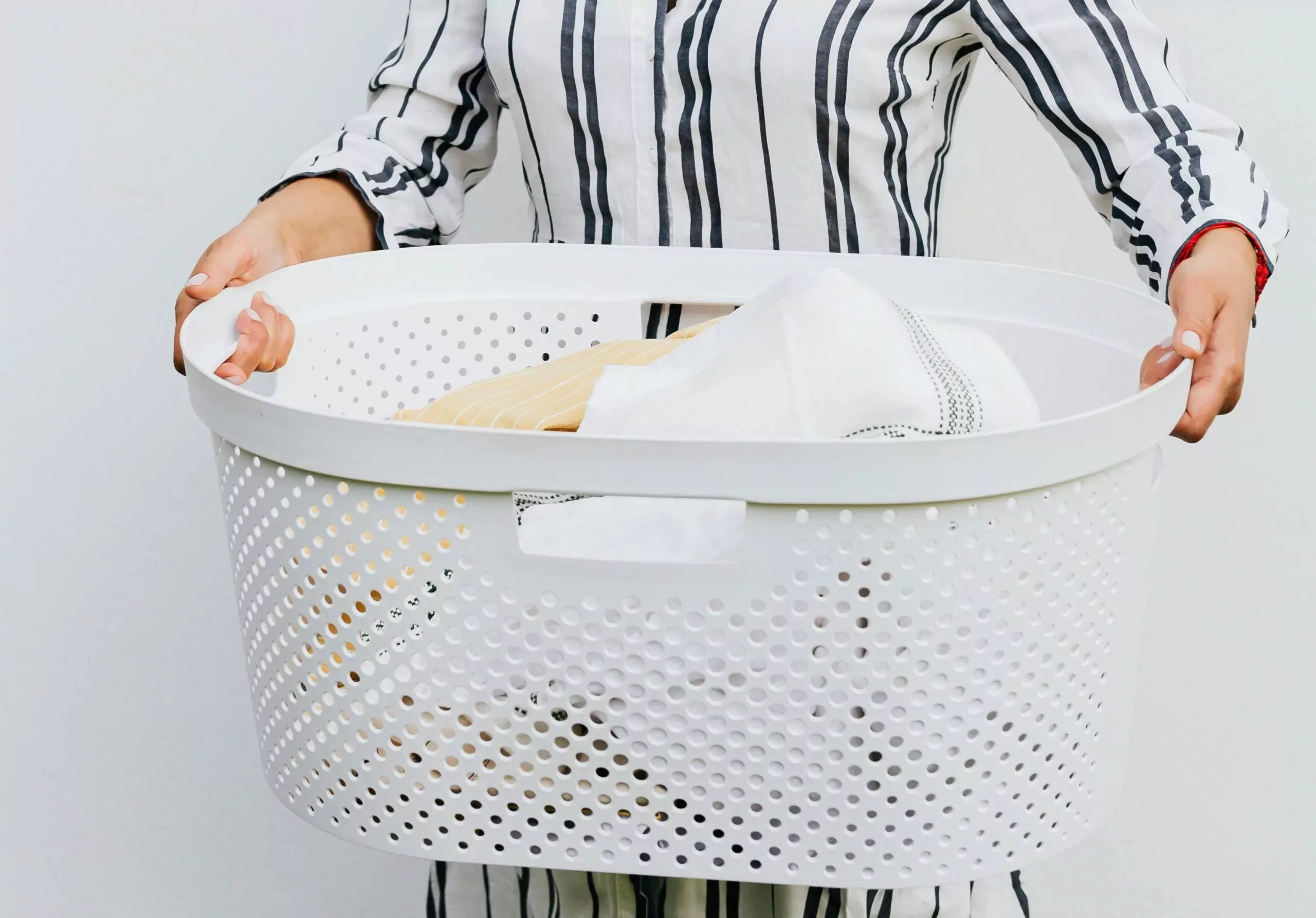 Person holding a laundry basket filled with clean clothes, showcasing on-site laundry facilities at Billing Aquadrome holiday park