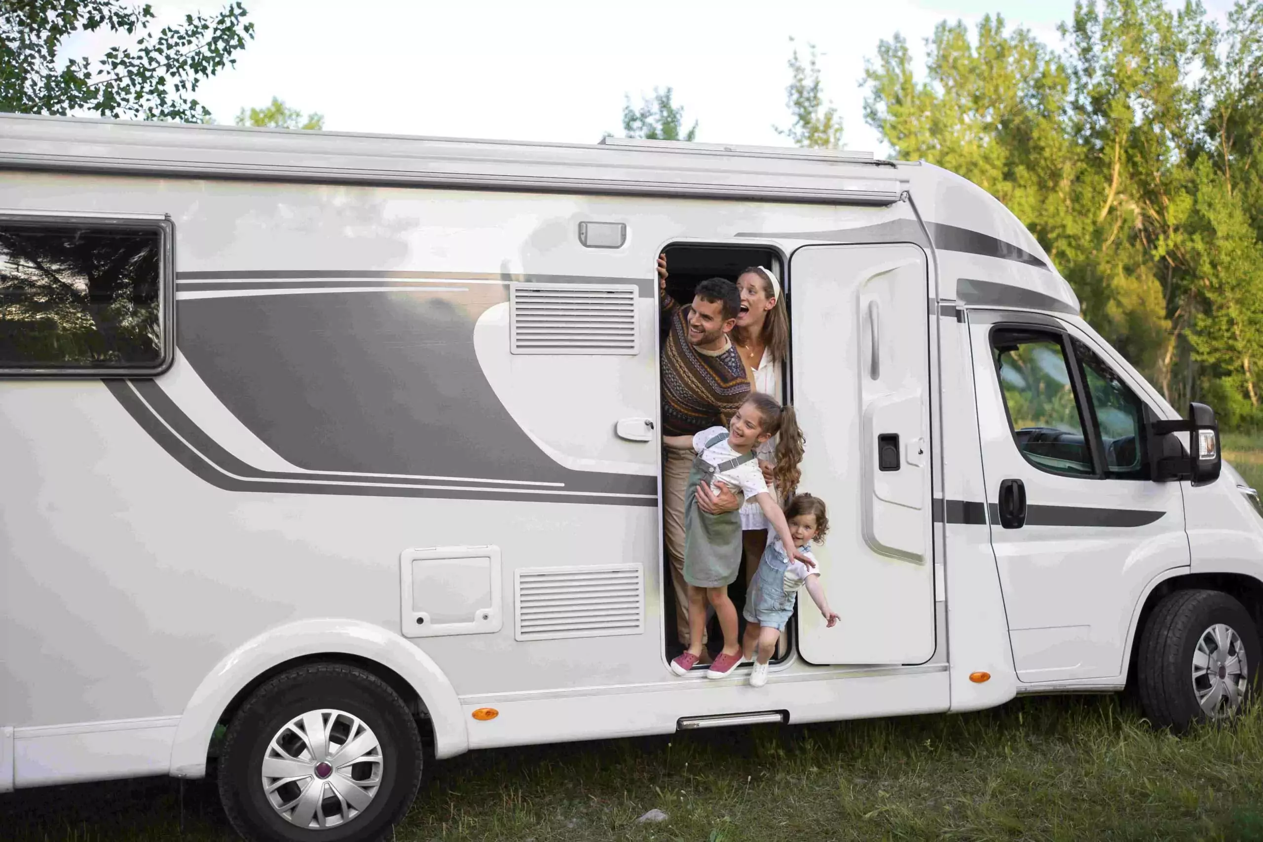 Smiling family stepping out of their motorhome at Meadow Bay Villages’ Billing Aquadrome, ready for a touring holiday adventure