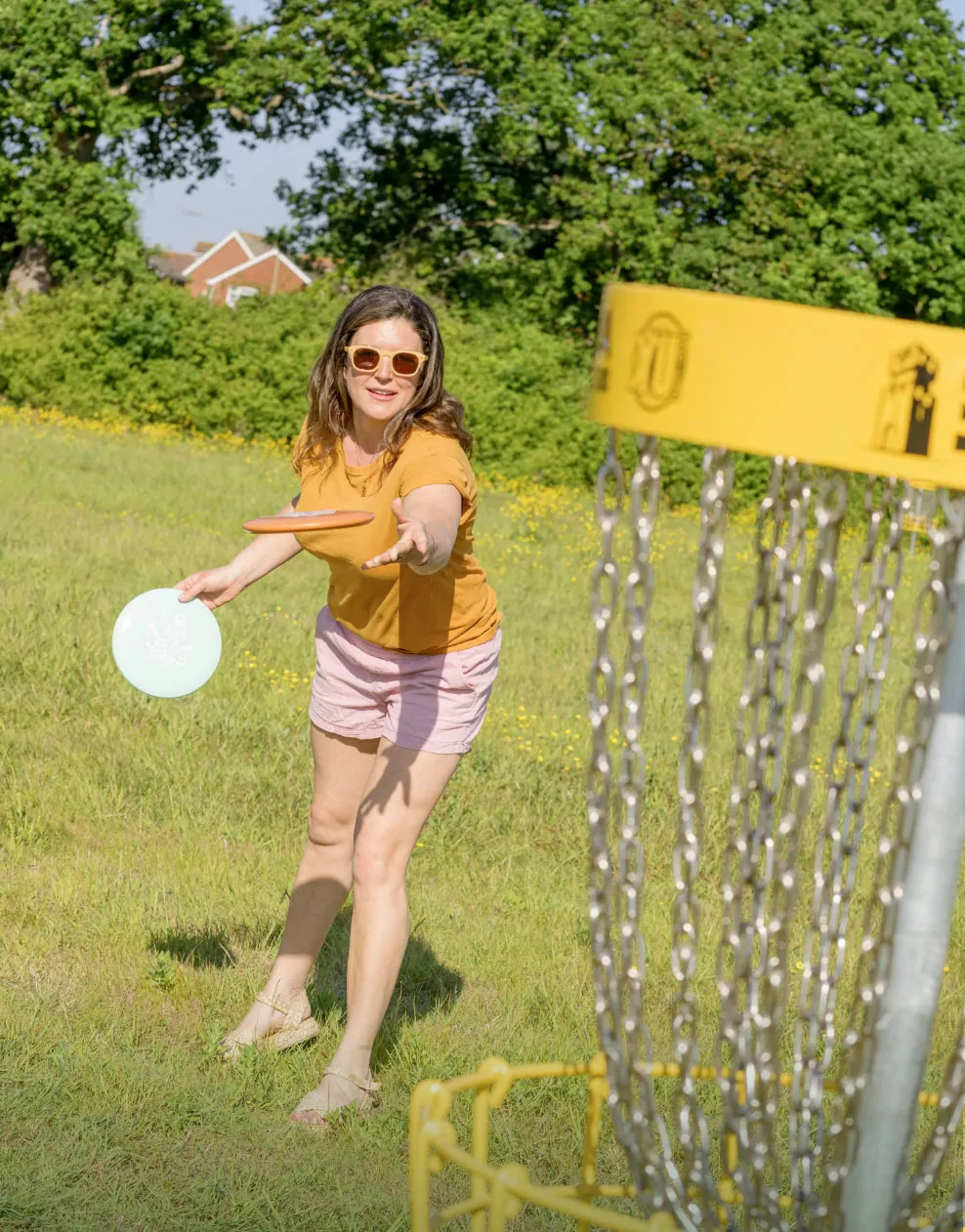 Woman playing a game of disc golf outdoors on the field at Billing Aquadrome.