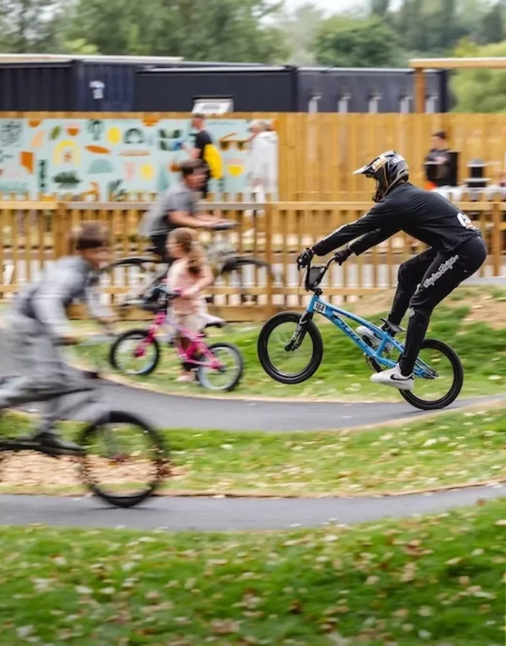 Cyclists racing and performing tricks on the pump track at Billing Aquadrome.