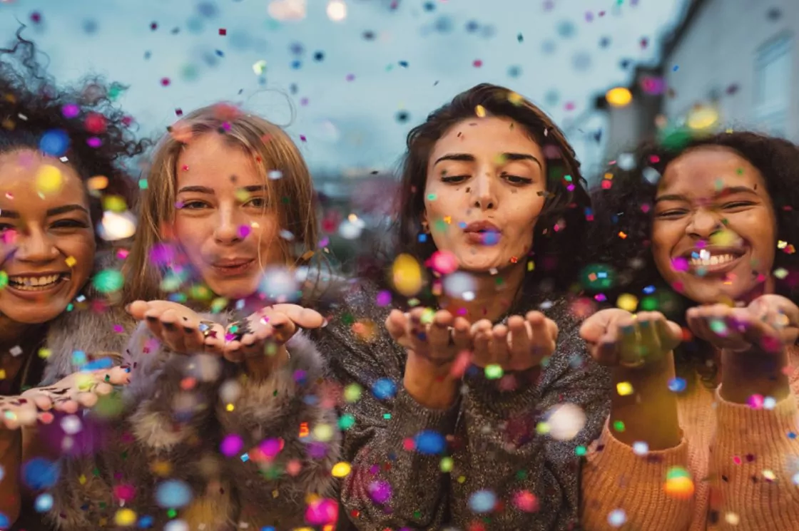 Friends celebrating and throwing colourful confetti during a fun event at Billing Aquadrome