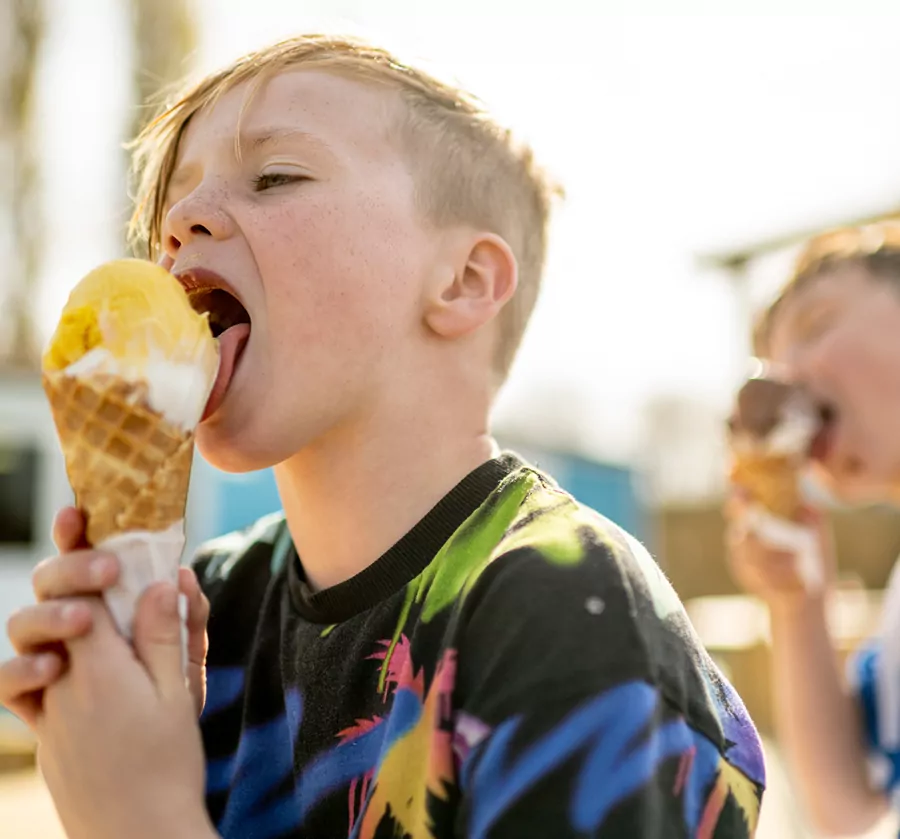 Young boy enjoying a waffle cone ice cream treat outside at Billing Aquadrome