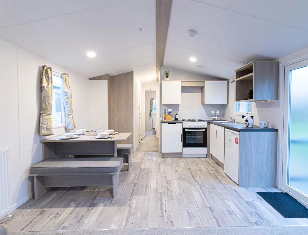 Modern kitchen and dining space in a Meadow Bay Villages holiday home, featuring light wood finishes and built-in seating.
