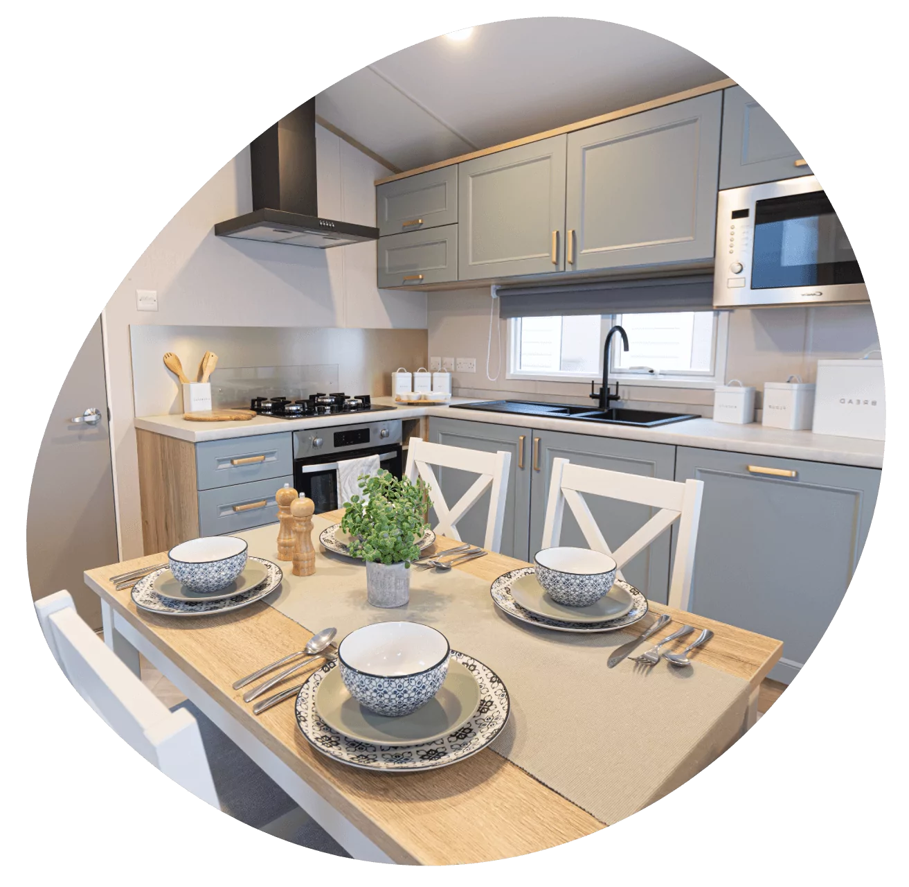 Modern kitchen and set dining table inside the First Step Pebble holiday home for sale at Golden Leas