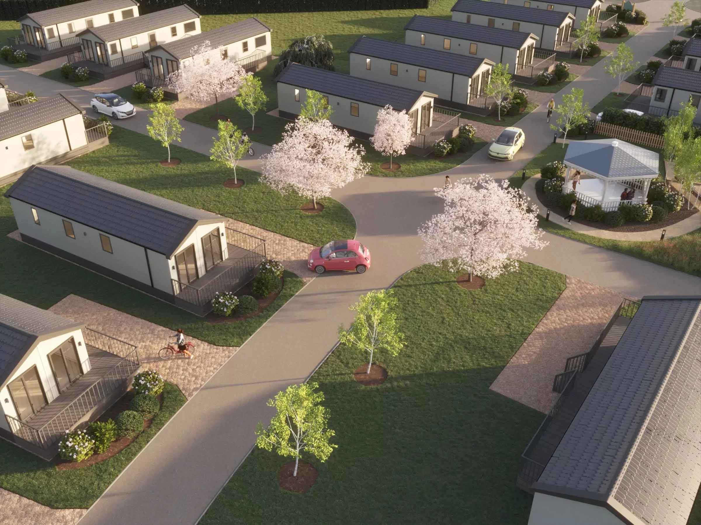 Aerial view of a holiday home park with landscaped gardens, blossom trees, and modern lodges at Hayling Island.