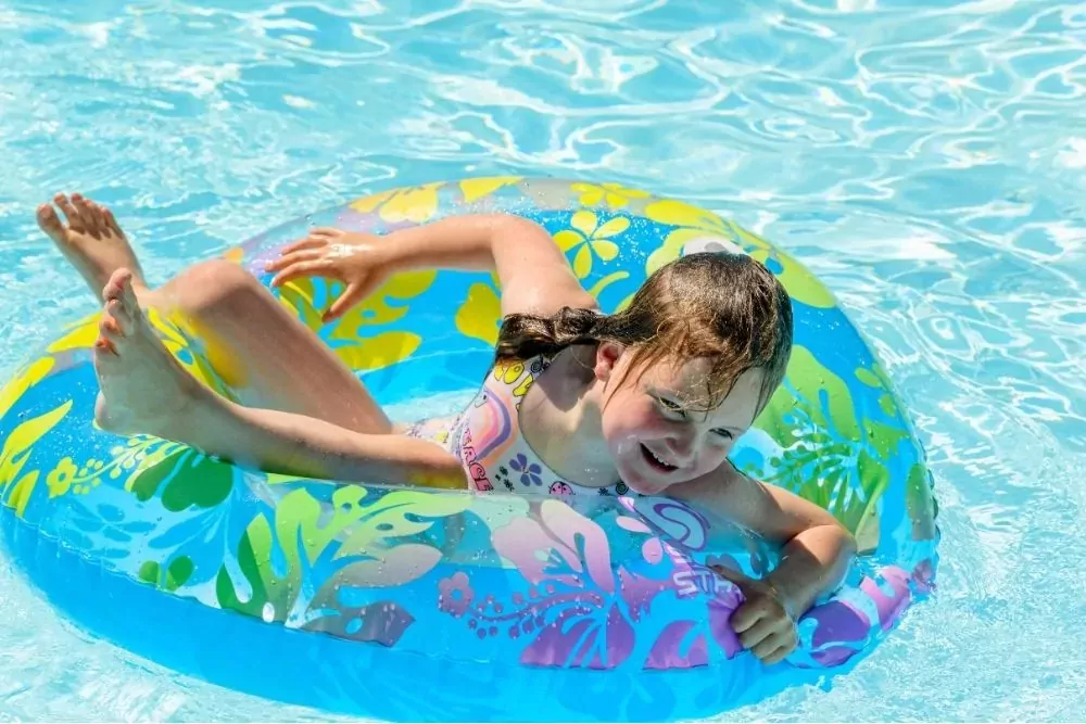 A young girl having fun on a colourful inflatable ring in the pool on Hayling Island.