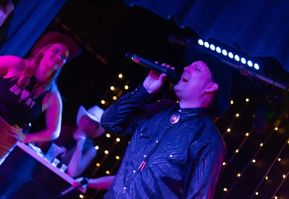 A country singer performing live on stage during an evening show on Hayling Island.