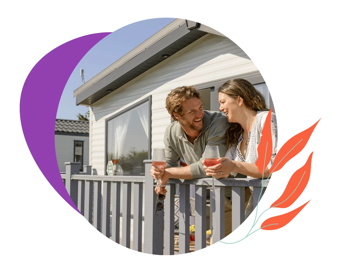 A happy couple, a man and a woman, standing on the balcony of their holiday home, laughing and holding glasses of rosé wine, enjoying the sunny weather, Hayling Island.