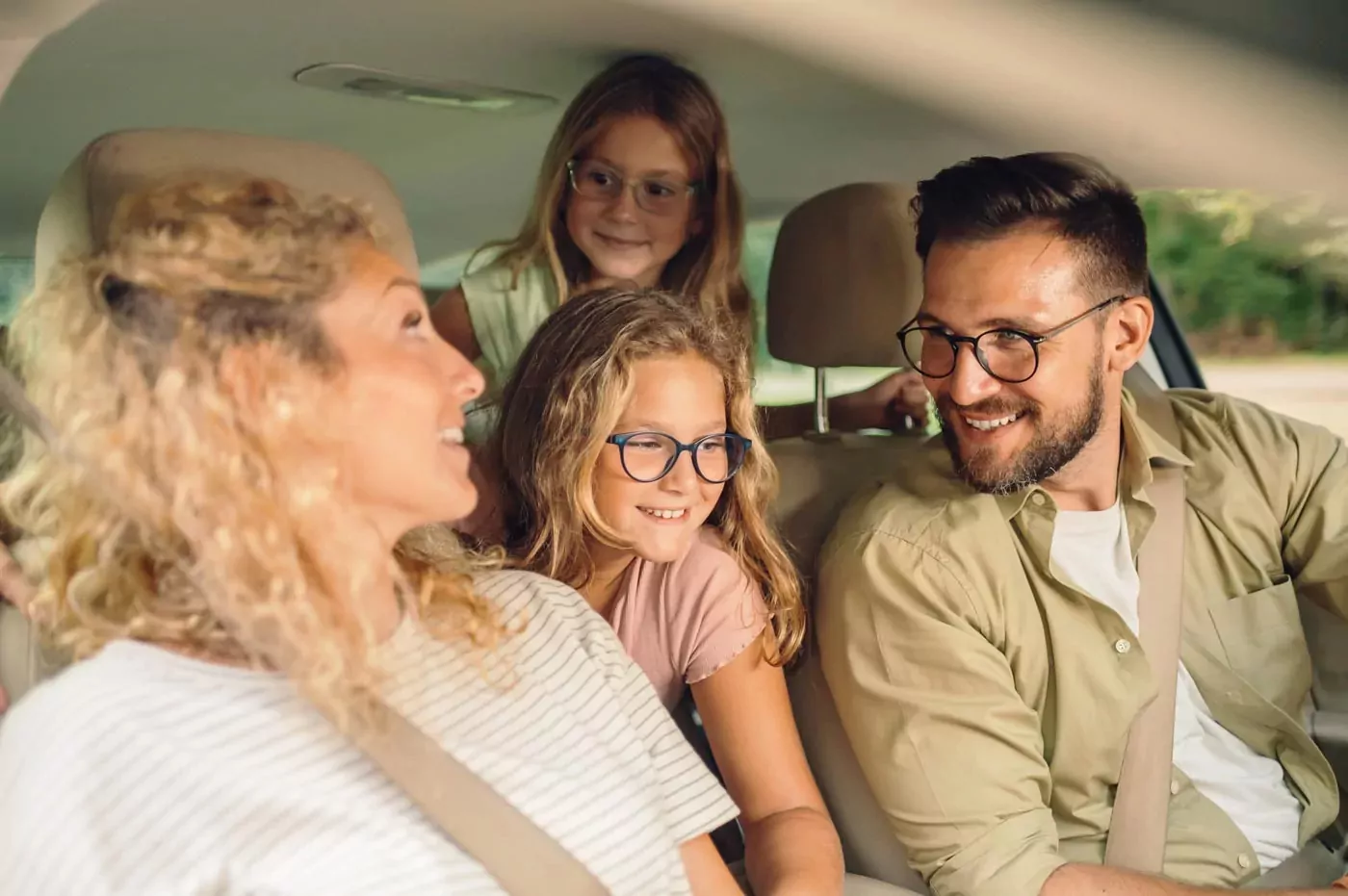 A happy family of four smiling and talking while on a car journey Hayling Island
