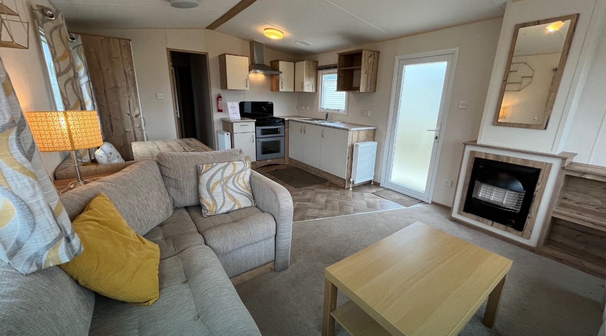 A cosy bronze caravan at Hayling Island with a comfortable lounge and kitchen space.