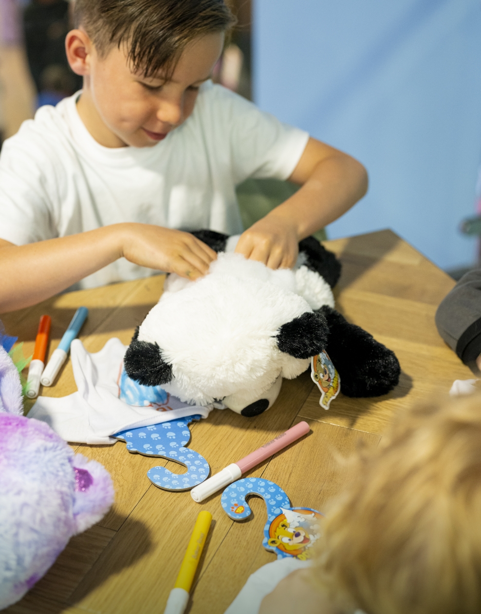 A young boy creating a cuddly panda bear at the Build-A-Bear activity in Hayling Island.