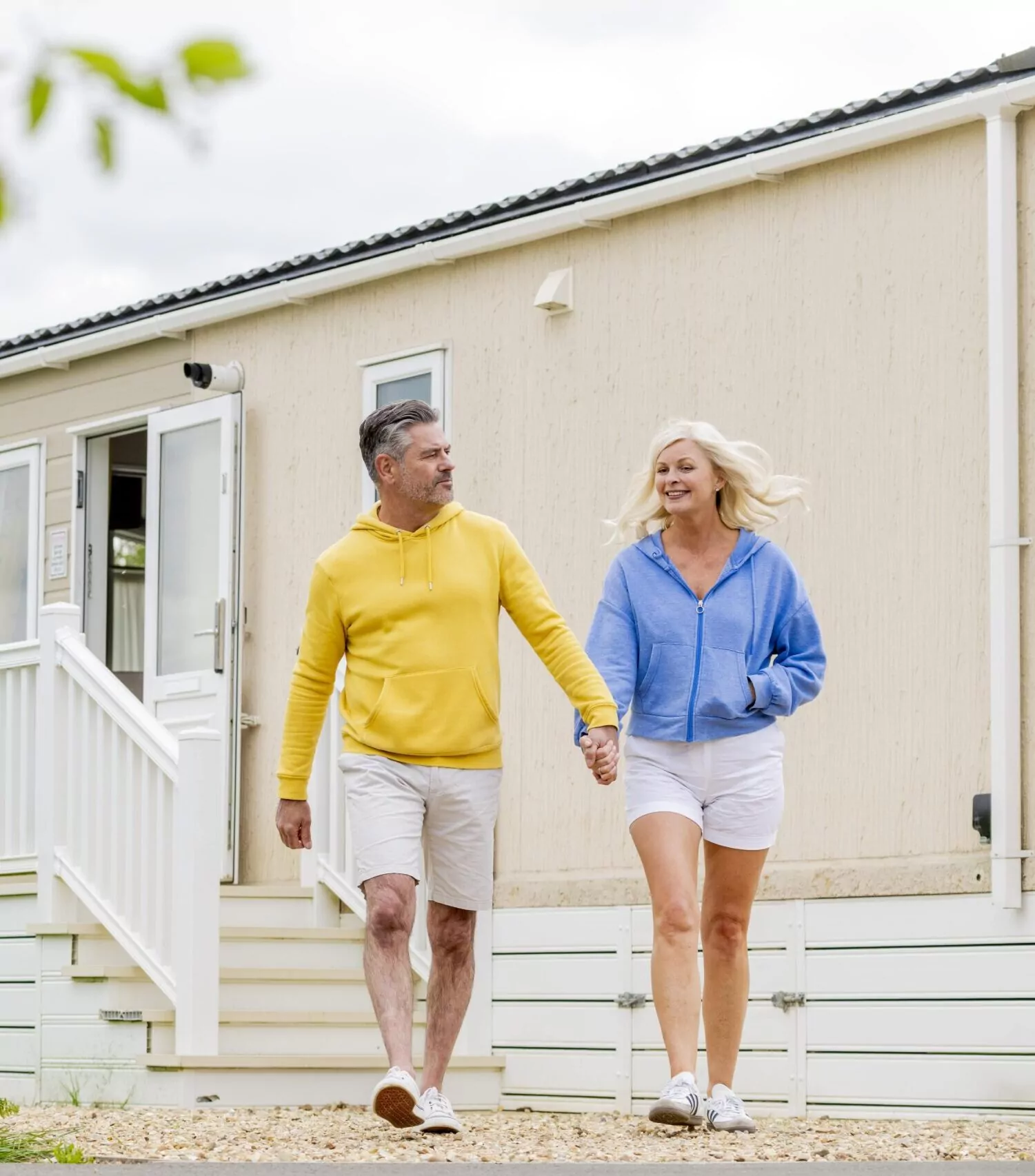 Couple holding hands walking away from a holiday home