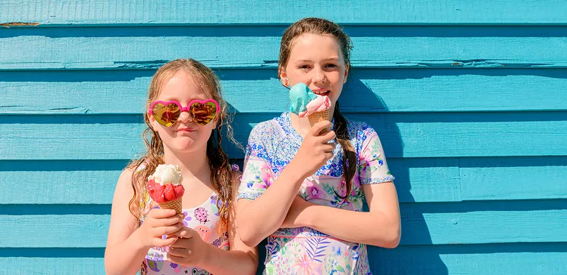 Two children enjoying ice cream outdoors on a sunny day, Hayling Island