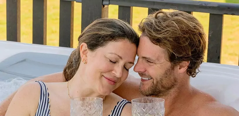 Couple relaxing together in a hot tub with drinks during a peaceful break, Hayling Island