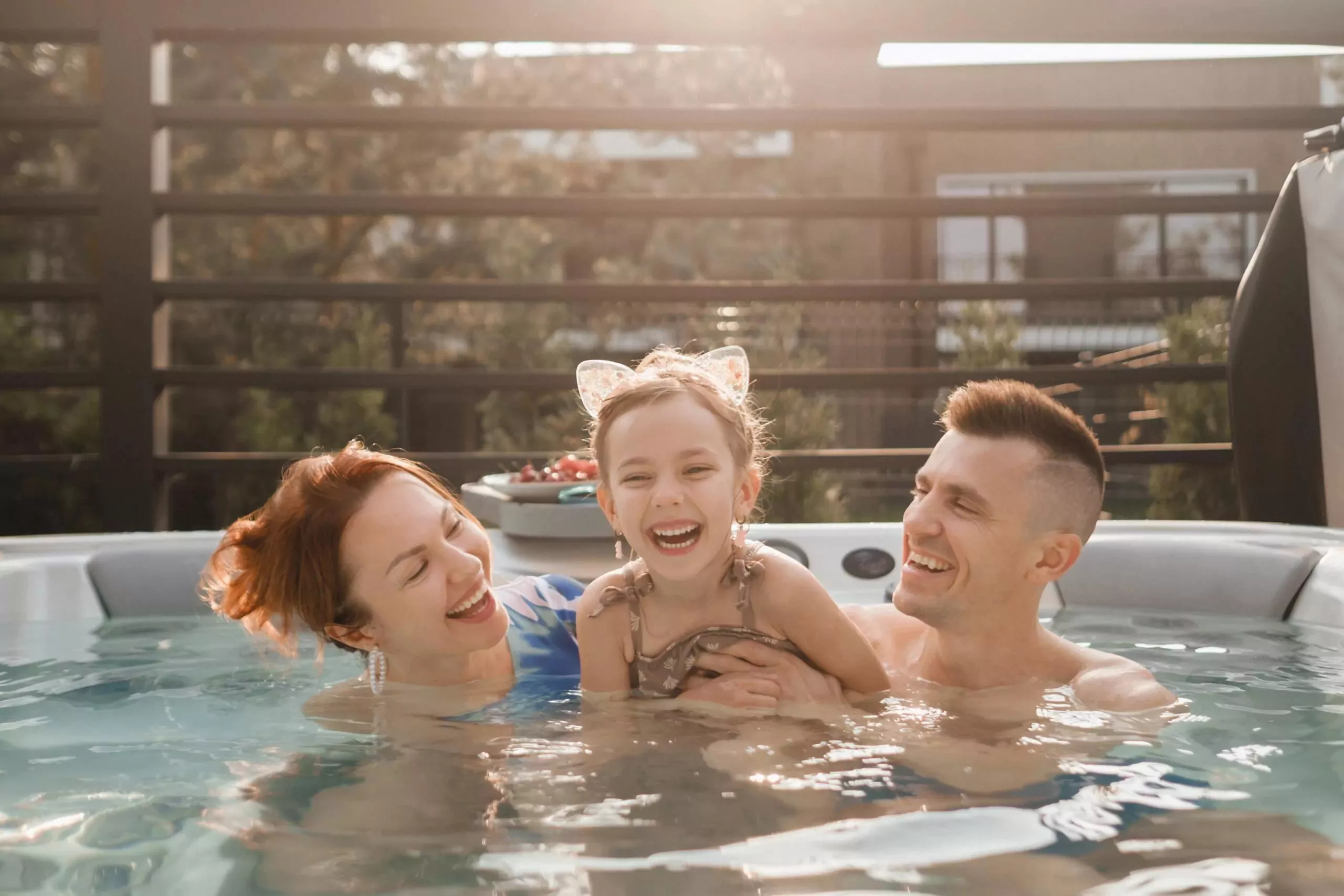 A happy family enjoying time together in a hot tub, laughing and smiling under the sunshine at Hayling Island.