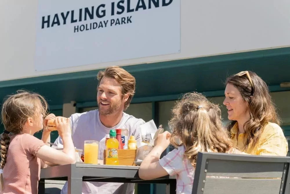 A family enjoying lunch together outside at the Hayling Island Holiday Park.
