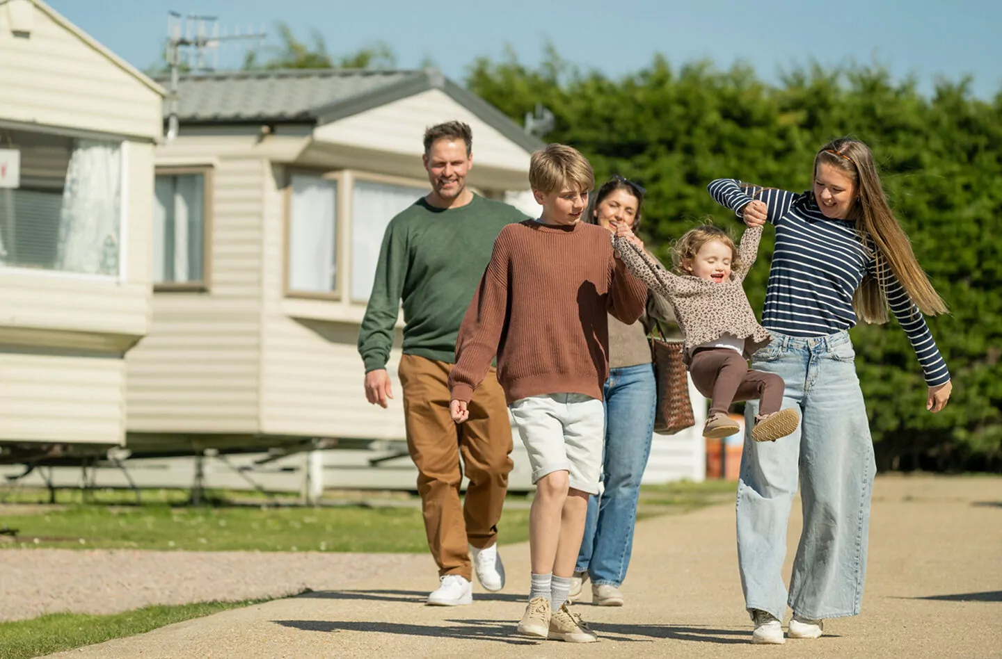 Family walking together outside holiday caravans at the holiday park, Hayling Island