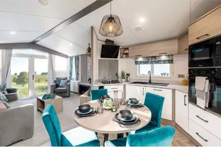 Happy couple walking their dog at the holiday park with pre-loved holiday homes available at Hollybush farm