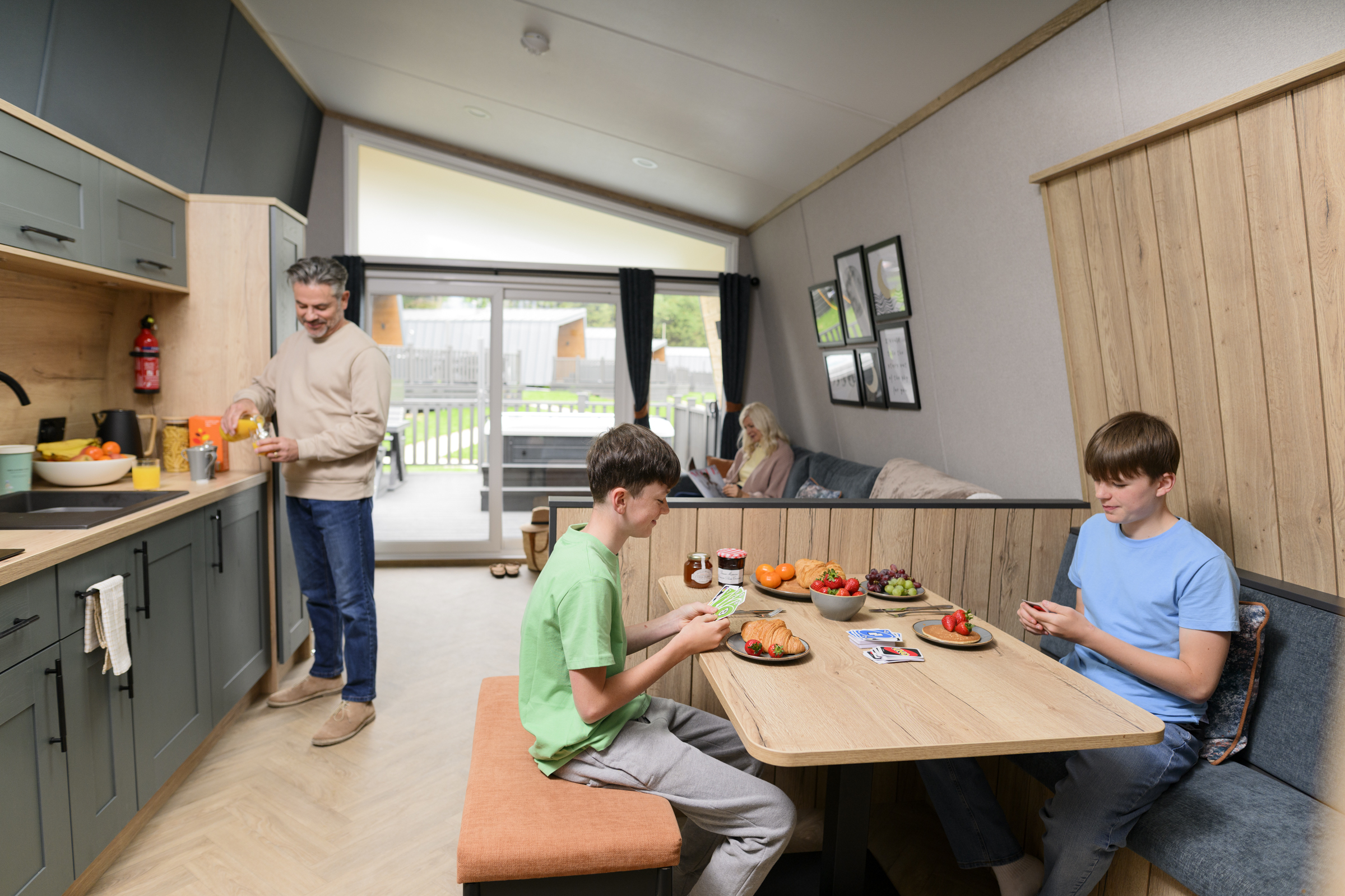 Family enjoying breakfast and games inside a modern holiday lodge at Billing Aquadrome