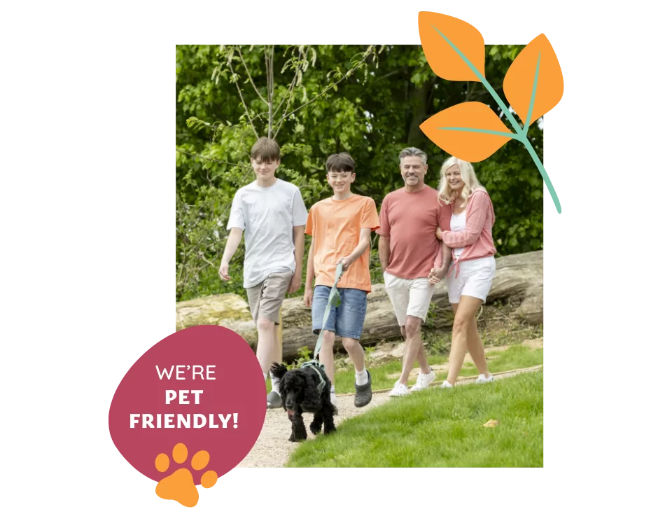 Family walking together outdoors with their small black dog at Meadow Bay Villages